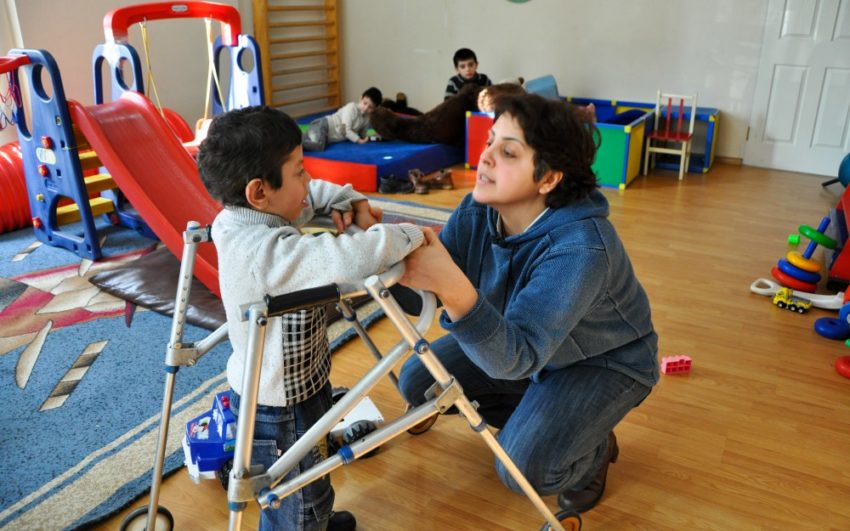 Woman helping child with special needs.