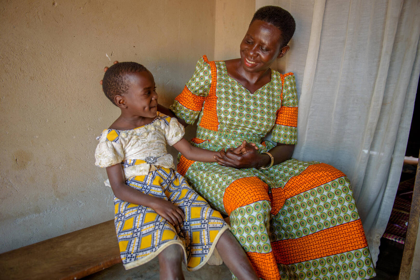 Rebecca and granddaughter Rebecca holds her granddaughter’s hand as they sit next to each other.