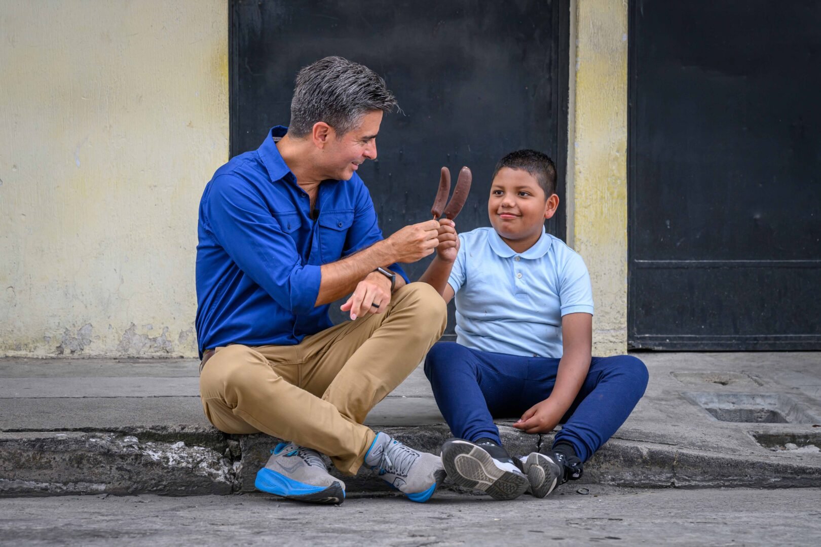 edgar eating a chocolate banana with a little kid