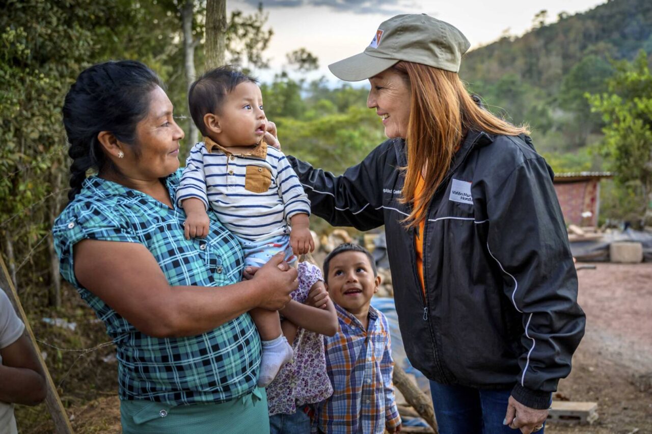 Checking on sponsored children, World Vision Program Manager Elda Solorzano meets with parents and children in Yamaranguila, Honduras.