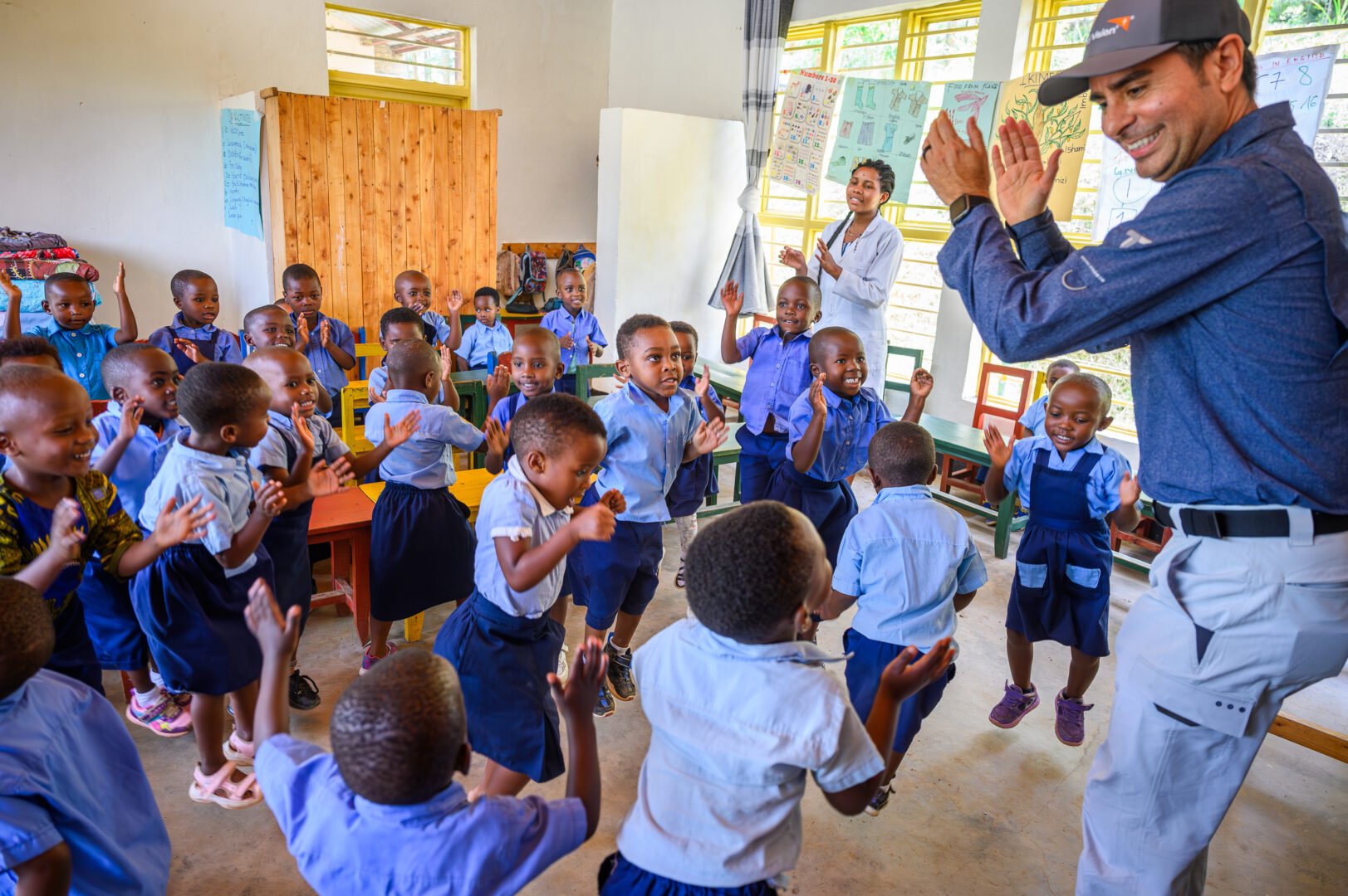 edgar clapping and dancing with a group of kids in school