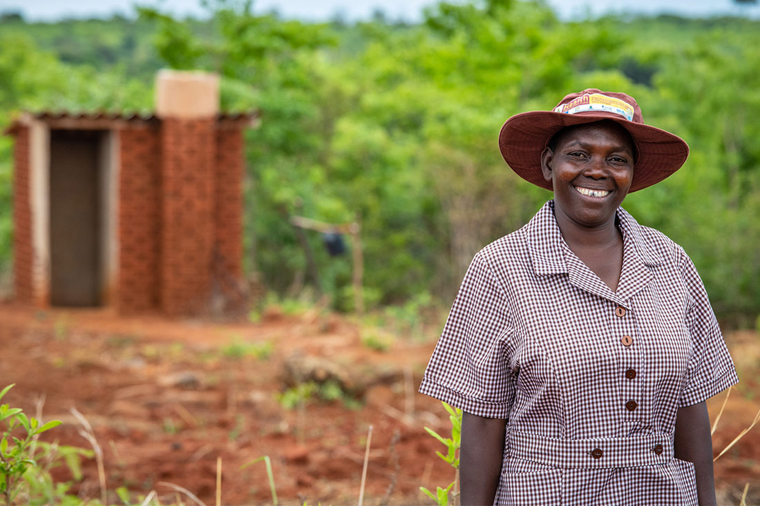 Gertrude stands in a field at her home in Zimbabwe