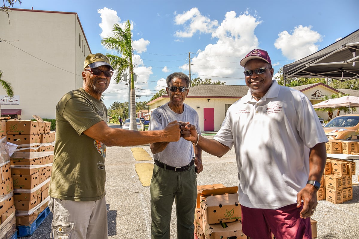 three men fist bumping