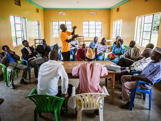man teaching group of men sitting down