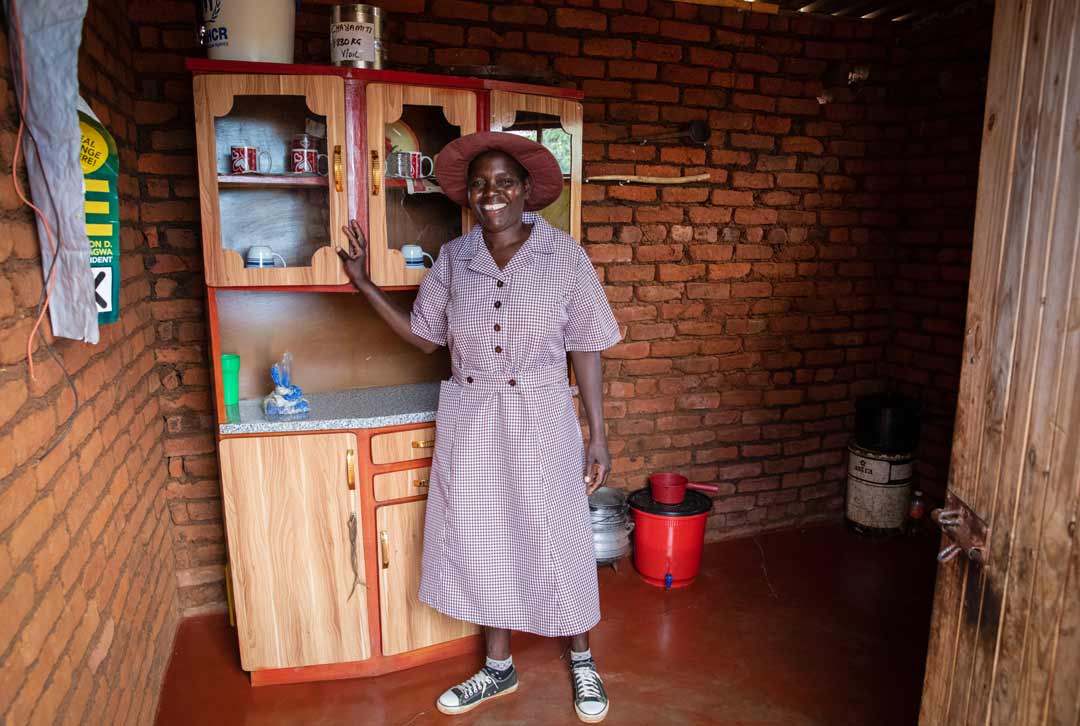 A woman stands in front of a cupboard