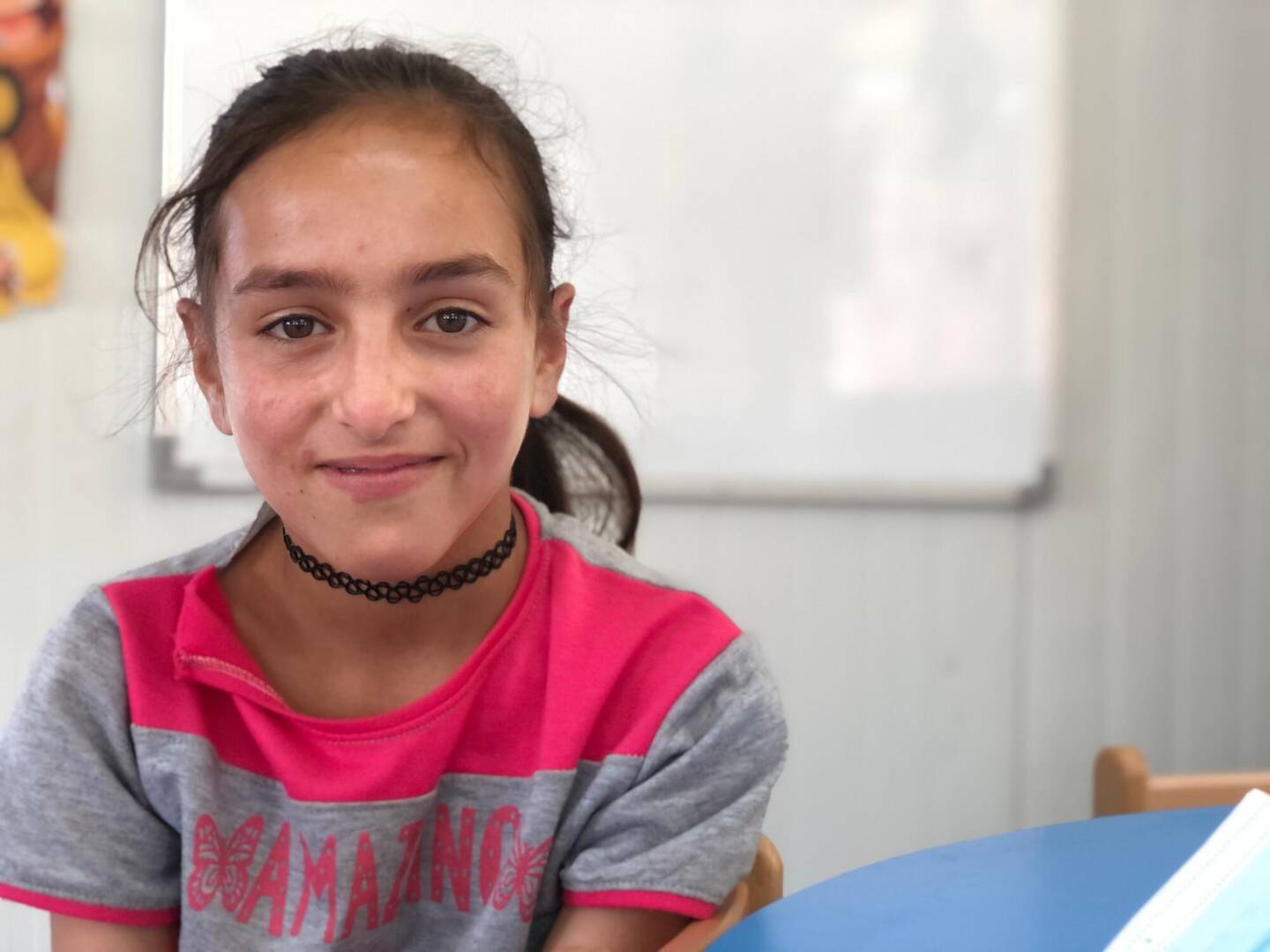 Walaa, a Syrian girl, sits at a table in a World Vision Child-Friendly Space that offers a safe place for children.