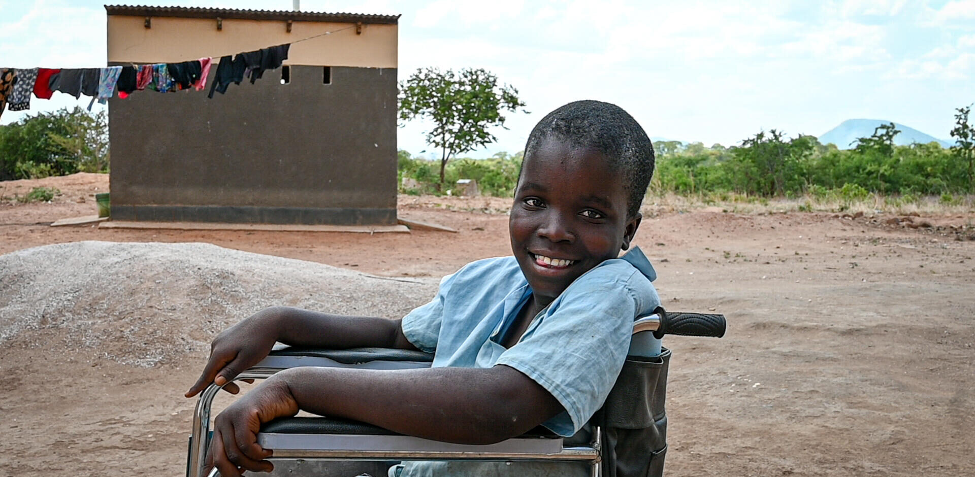 Mary smiles A Zambian girl smiles at the camera while she sits in her wheelchair.