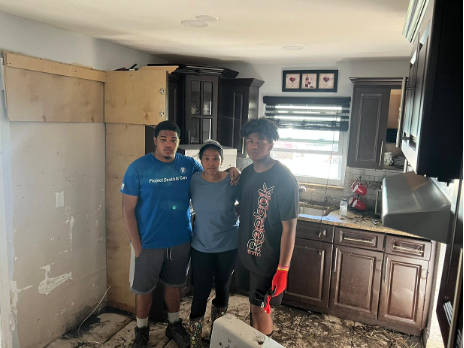 A woman and her sons stand in the ruins of their kitchen after Hurricane Ian battered their house in Florida.